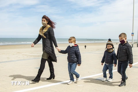 Người dân dạo trên bãi biển ở Dunkirk, Pháp. (Ảnh: THX/TTXVN)