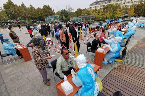 Nhân viên y tế lấy mẫu xét nghiệm COVID-19 cho người dân tại thành phố Thanh Đảo, tỉnh Sơn Đông, Trung Quốc ngày 13/10/2020. (Ảnh: AFP/TTXVN)