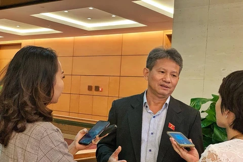Đại biểu Đỗ Văn Sinh trao đổi với phóng viên bên hành lang Quốc hội. (Ảnh: Xuân Mai/Vietnam+)