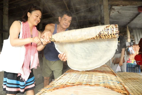 Du khách trải nghiệm làm bánh tráng ở Cần Thơ. (Ảnh: CTV/Vietnam+)