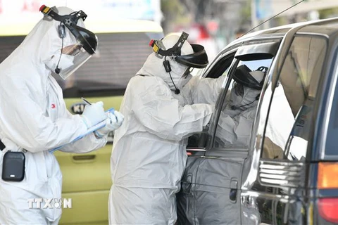 Nhân viên y tế kiểm tra thân nhiệt lái xe nhằm ngăn ngừa sự lây lan của virus SARS-CoV-2 tại Goyang, phía Bắc Seoul ngày 29/2/2020. (Ảnh: AFP/TTXVN)