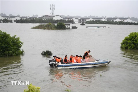 Người dân đi thuyền qua vùng ngập lụt tại huyện Túc Tùng, tỉnh An Huy, miền đông Trung Quốc ngày 15/7/2020. (Ảnh: THX/TTXVN)