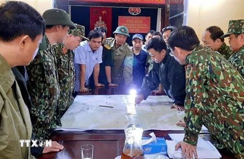 Chủ tịch UBND huyện Phong Điền Nguyễn Văn Bình (sơ mi ngắn tay xanh nhạt) họp bàn trước lúc lên đường cứu trợ đoàn công nhân mất tích tại Thủy điện Rào Trăng 3. (Ảnh: TTXVN phát)