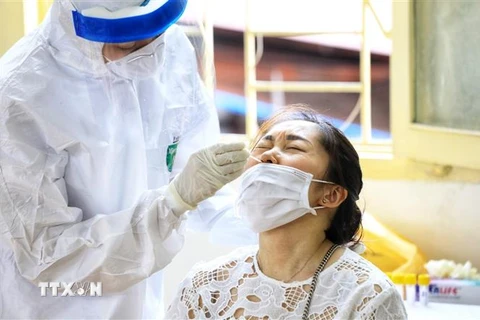 Nhân viên y tế quận Hoàn Kiếm tiến hành lấy mẫu xét nghiệm COVID-19 cho người dân từ Đà Nẵng trở về. (Ảnh: Thành Đạt/TTXVN)