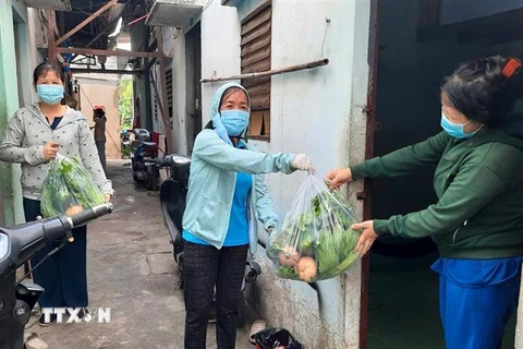 Liên đoàn Lao động quận Gò Vấp trao tặng rau xanh cho công nhân lao động trong khu trọ có hoàn cảnh khó khăn. (Ảnh: Thanh Vũ/TTXVN)