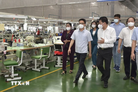 Phó Thủ tướng Vũ Đức Đam kiểm tra mô hình '3 tại chỗ' tại Công ty TNHH New Apparel Far Eastern Việt Nam (Khu công nghiệp Bắc Đồng Phú, thị trấn Tân Phú, huyện Đồng Phú). (Ảnh: Diệp Trương/TTXVN)