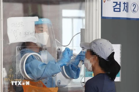 Nhân viên y tế lấy mẫu xét nghiệm COVID-19 cho người dân tại Seoul, Hàn Quốc, ngày 1/8/2021. (Ảnh: Yonhap/TTXVN)