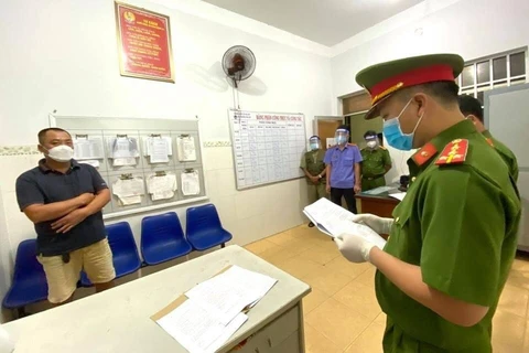 Công an Phú Mỹ đọc quyết định khởi tố bị can và bắt tạm giam đối với Trần Quang Minh. (Ảnh do công an cung cấp)