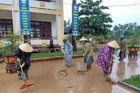 Phụ nữ tham gia dọn dẹp vệ sinh khắc phục hậu quả sau mưa lũ. (Ảnh: Võ Dung/TTXVN)
