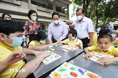 Thủ tướng Phạm Minh Chính thăm trẻ em đang được chăm sóc tại Trung tâm bảo trợ trẻ tàn tật mồ côi Thị Nghè. (Ảnh: Dương Giang/TTXVN)