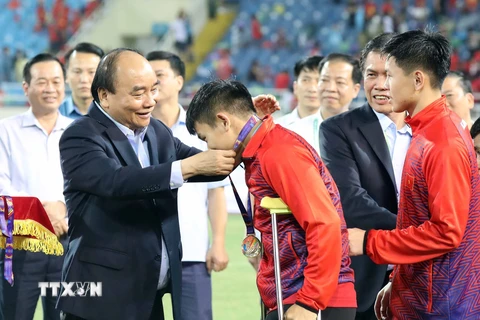 Chủ tịch nước Nguyễn Xuân Phúc trao huy chương Vàng cho các cầu thủ U23 Việt Nam. (Ảnh: Thống Nhất/TTXVN)