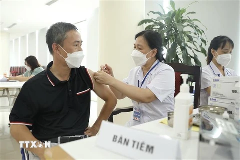 Nhân viên y tế quận Hoàn Kiếm tiêm vaccine phòng COVID-19 mũi nhắc 2 (mũi 4) cho cán bộ, nhân viên cơ quan Thông tấn xã Việt Nam ngày 5/8. (Ảnh: Minh Quyết/TTXVN)