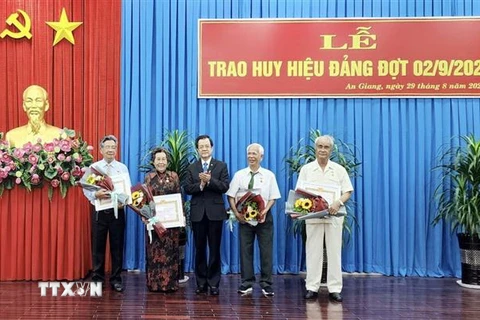 Ông Lê Hồng Quang, Bí thư Tỉnh ủy An Giang, trao huy hiệu 60 năm tuổi Đảng cho 4 đảng viên. (Ảnh: Thanh Sang/TTXVN)