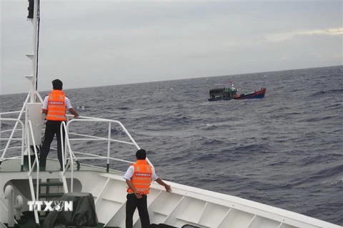 Tàu Hải quân 473 lai kéo tàu cá QNg 90379TS về đảo Song Tử Tây. (Ảnh: TTXVN phát)