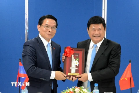 Ông Vilayvong Bouddakham (trái) tặng quà lưu niệm cho ông Huỳnh Cách Mạng. (Ảnh: Xuân Khu/TTXVN)