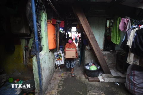 Người dân nghèo nhận nhu yếu phẩm hỗ trợ tại Jakarta, Indonesia ngày 9/4/2020 trong bối cảnh dịch COVID-19 lan rộng. (Ảnh: THX/TTXVN)