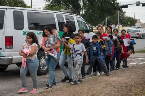 Người di cư tới trung tâm tiếp nhận ở McAllen, Texas, Mỹ. (Ảnh: AFP/TTXVN)