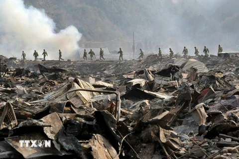 Lực lượng Phòng vệ Nhật Bản tìm kiếm nạn nhân tại khu vực bị tàn phá sau thảm họa động đất sóng thần ở tỉnh Iwate, Nhật Bản ngày 13/3/2011. (Ảnh: AFP/TTXVN)