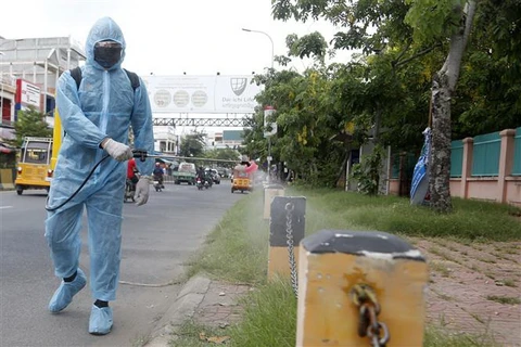 Nhân viên y tế Campuchia phun thuốc khử trùng nhằm ngăn chặn sự lây lan của COVID-19. (Ảnh: THX/TTXVN)