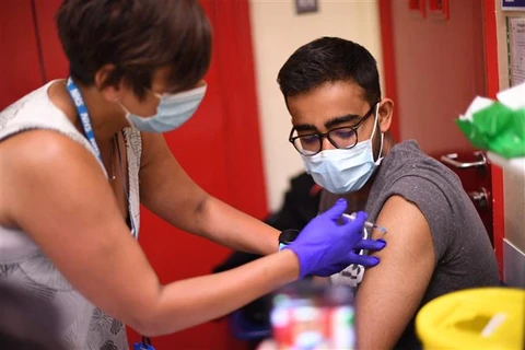 Nhân viên y tế tiêm vaccine ngừa COVID-19 cho người dân tại London, Anh. (Ảnh: AFP/TTXVN)