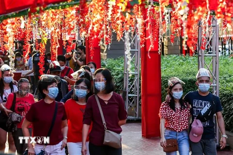 Người dân đeo khẩu trang phòng lây nhiễm COVID-19 trong kỳ nghỉ lễ Nguyên đán. (Ảnh: THX/ TTXVN)