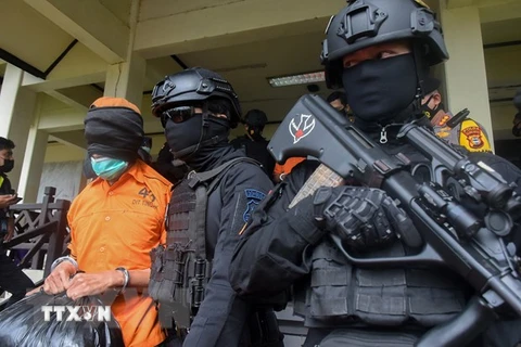 Cảnh sát áp giải nghi phạm khủng bố tại Makassar, Indonesia. (Ảnh: AFP/TTXVN)