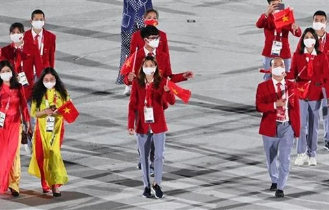 Đoàn thể thao Việt Nam diễu hành tại lễ khai mạc Olympic Tokyo 2020 trên sân vận động Olympic ở Tokyo (Nhật Bản), ngày 23/7/2021. (Ảnh: AFP/TTXVN) 