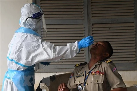 Nhân viên y tế lấy mẫu xét nghiệm COVID-19 cho người dân tại Phnom Penh, Campuchia. (Ảnh: AFP/TTXVN) 