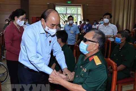 Chủ tịch nước Nguyễn Xuân Phúc đến thăm, tặng quà cho thương binh, bệnh binh tại Trung tâm nuôi dưỡng thương bệnh binh nặng và điều dưỡng người có công tỉnh Hà Nam. (Ảnh: Thống Nhất/TTXVN) 