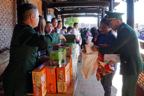 Bộ đội Biên phòng tỉnh Quảng Nam tặng quà cho các hộ gia đình có hoàn cảnh khó khăn tại Phiên chợ không đồng. (Ảnh: Trịnh Bang Nhiệm/TTXVN)