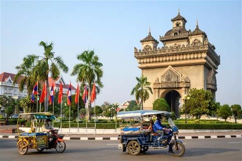 Xe tuk tuk di chuyển trên đường phố tại Vientiane (Lào). (Ảnh: AFP/TTXVN)