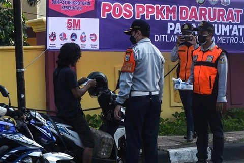 Nhân viên Bộ giao thông phát khẩu trang cho người dân để phòng tránh lây nhiễm COVID-19 tại Jakarta (Indonesia), ngày 3/7/2021. (Ảnh: THX/TTXVN)