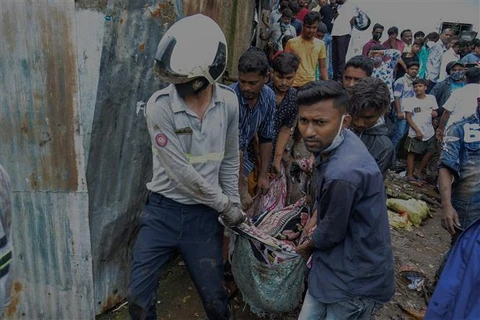 Nhân viên cứu hộ chuyển người thiệt mạng trong vụ lở đất ở Mumbai (Ấn Độ), ngày 18/7/2021. (Ảnh: AFP/TTXVN)