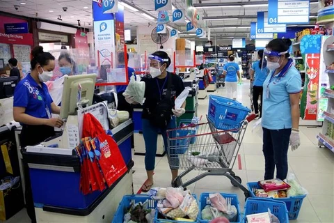 Hội viên Hội Liên hiệp phụ nữ Thành phố Hồ Chí Minh đi chợ giúp người dân mua hàng hóa, lương thực tại siêu thị Co.op Nhiêu Lộc-Thị Nghè. (Ảnh: Thanh Vũ/TTXVN)
