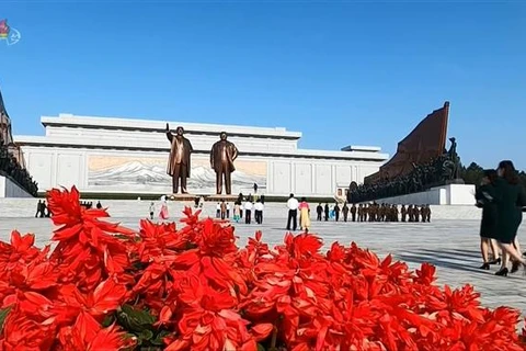 Người dân tới đặt hoa tại tượng đài cố Chủ tịch Kim Nhật Thành và cố lãnh đạo Kim Jong-il tại Bình Nhưỡng (Triều Tiên), ngày 15/4/2021. (Ảnh: Yonhap/TTXVN)