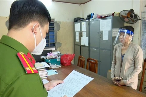 Nguyễn Thị Kim Hạnh (tức Mười Tường) nghe công an đọc quyết định khởi tố. (Ảnh: TTXVN)