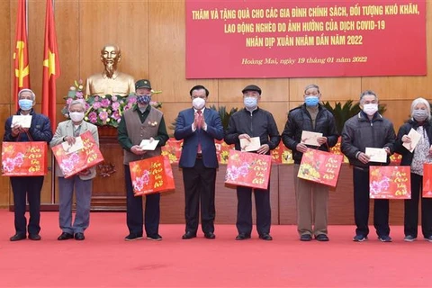 Bí thư Thành ủy Hà Nội Đinh Tiến Dũng trao quà cho các gia đình chính sách, đối tượng khó khăn, lao động nghèo, tại quận Hoàng Mai. (Ảnh: TTXVN)