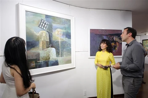 Khách nước ngoài xem triển lãm mỹ thuật "Hội ngộ." (Ảnh: Trần Lê Lâm/TTXVN)