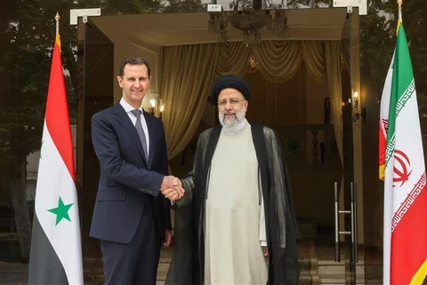 Tổng thống Iran Ebrahim Raisi (phải) và Tổng thống Syria Bashar al-Assad tại cuộc gặp ở Tehran, ngày 8/5/2022. (Ảnh: AFP/TTXVN)