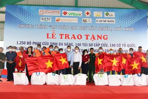 Tặng cờ, túi sơ cấp cứu, phao cứu sinh đa năng cho ngư dân Bình Thuận. (Ảnh: Nguyễn Thanh/TTXVN)