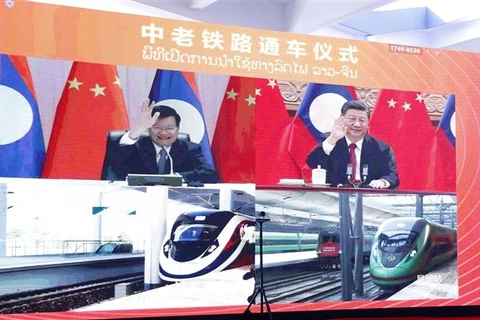 Lãnh đạo Lào và Trung Quốc vẫy tay chào hai đoàn tàu đang xuất phát khỏi ga Vientiane và ga Côn Minh, trong lễ khánh thành tuyến đường sắt Lào-Trung ngày 3/12/2021. (Ảnh: Phạm Kiên/TTXVN)