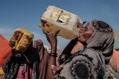 Người dân dùng nước được phân phối tại một trại tạm dành cho người sơ tán do hạn hán nghiêm trọng ở thị trấn thuộc Baidoa (Somalia), ngày 13/2/2022. (Ảnh: AFP/TTXVN)
