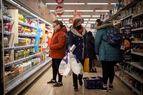 Người dân mua hàng tại siêu thị ở London (Anh). (Ảnh: AFP/TTXVN)