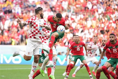 Achraf Hakimi (trên, phải) của Maroc giành bóng với những cầu thủ group Croatia. (Ảnh: THX/TTXVN)