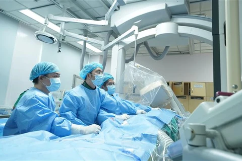 Các bác sỹ Bệnh viện Đại học Y dược thực hiện phẫu thuật thay van động mạch phổi qua da cho người bệnh. (Ảnh: TTXVN phát)