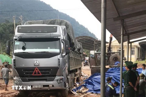 Số gỗ được giấu kín trong những kiện hàng phế liệu được các xe tải kéo rơmóc chở từ Lào về Việt Nam. (Ảnh: Thanh Thủy/TTXVN)