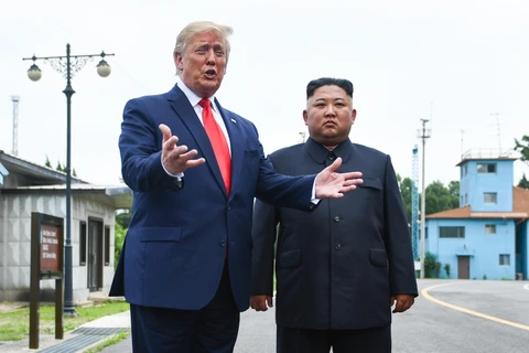 Tổng thống Mỹ Donald Trump (trái) và nhà lãnh đạo Triều Tiên Kim Jong-un trong cuộc gặp ở làng đình chiến Panmunjom tại Khu phi quân sự (DMZ) chiều 30/6/2019. (Nguồn: AFP/TTXVN)
