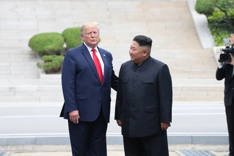 Tổng thống Mỹ Donald Trump (trái) và nhà lãnh đạo Triều Tiên Kim Jong-un trong cuộc gặp ở làng đình chiến Panmunjom tại Khu phi quân sự (DMZ) chiều 30/6/2019. (Nguồn: Yonhap/TTXVN)