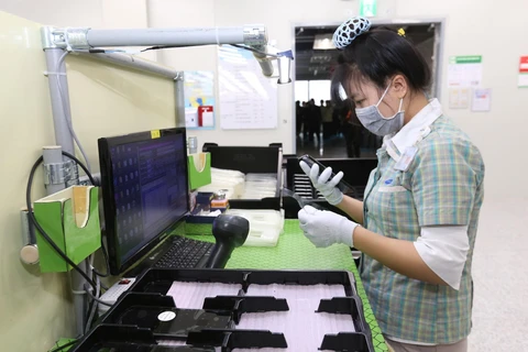 Người lao động tại Công ty trách nhiệm hữu hạn Samsung Electronics Việt Nam đeo khẩu trang và sử dụng các biện pháp phòng chống dịch viên đường hô hấp cấp COVID-19. (Ảnh: Anh Tuấn/TTXVN)