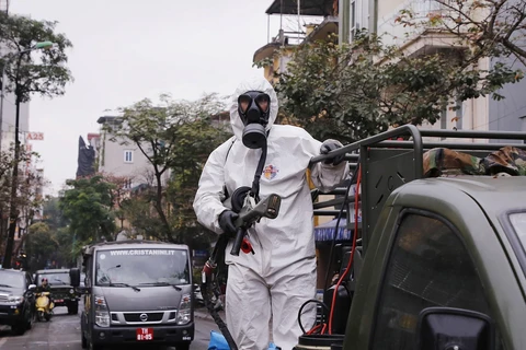Trong ảnh: Lực lượng bộ đội hóa học triển khai phun hóa chất tiêu tẩy khu vực phố Châu Long, quận Ba Đình. (Ảnh: Dương Giang/TTXVN)
